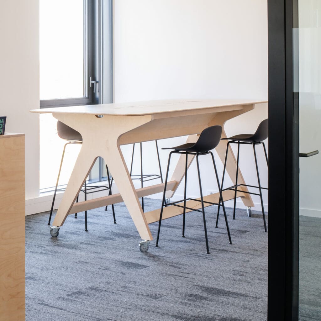 Espace de réunion avec table haute en bois clair