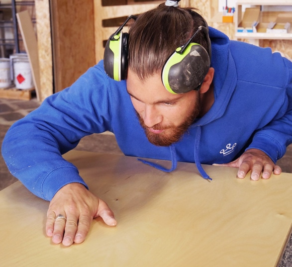 Un homme qui contrôle la qualité du mobilier dans une usine de fabrication de meuble en bois