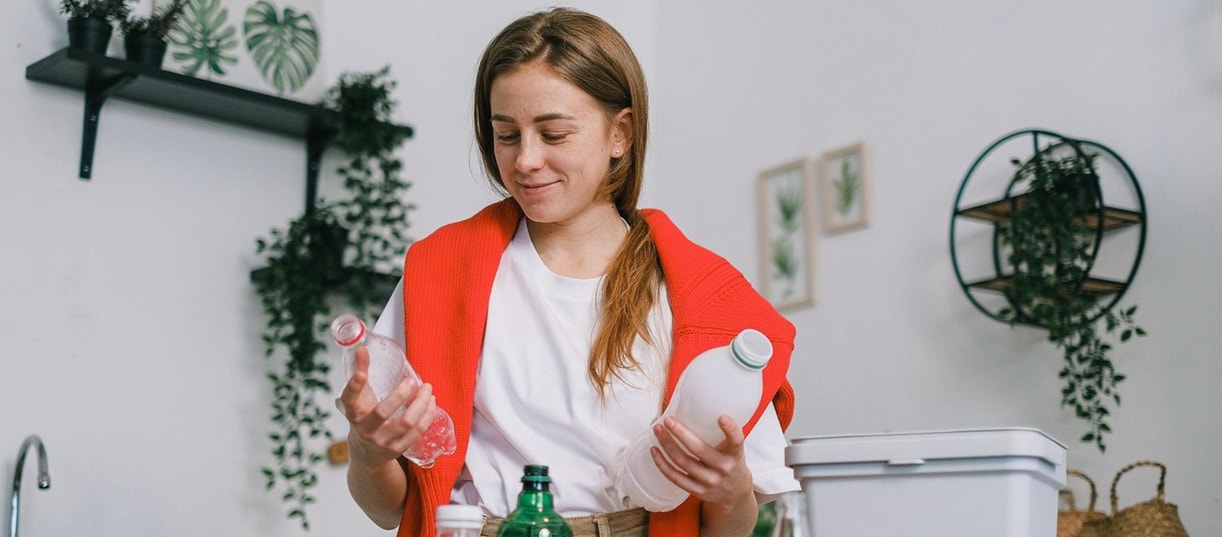 une femme fait le tri sélectif dans une cuisine