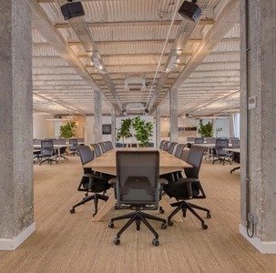 aménagement de grands bureaux en open space avec longue table de travail et sièges ergonomiques