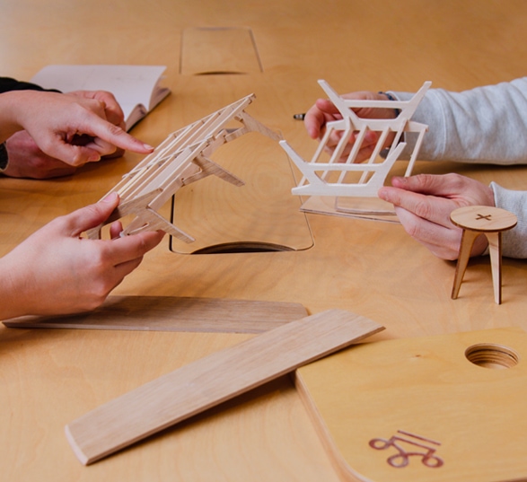 personnes qui touchent des maquettes de bureaux en bois