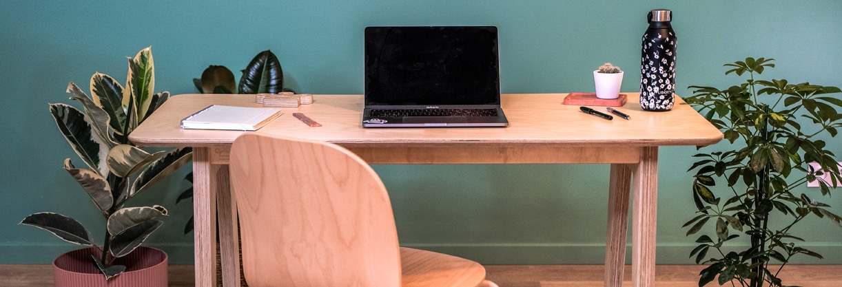 un bureau en bois de télétravail avec un ordinateur des plantes et une chaise en bois