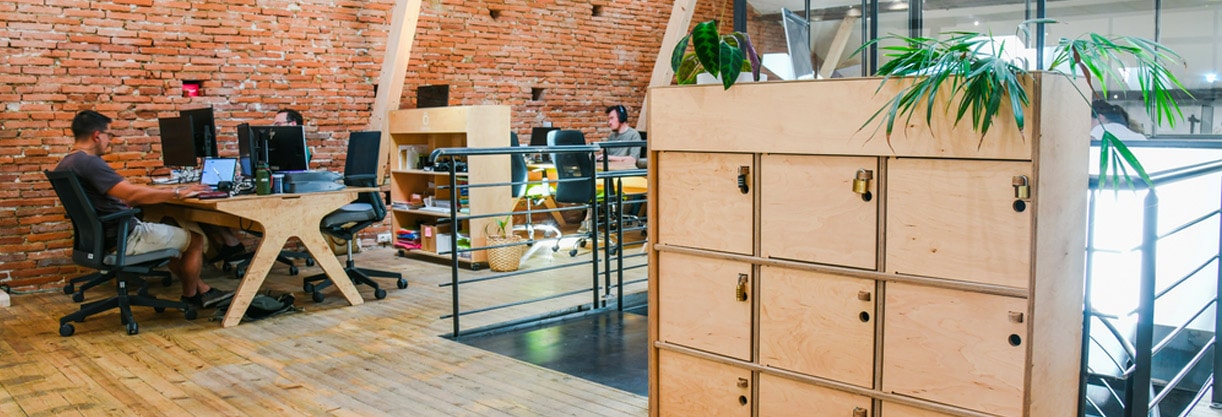 un casier de rangement en bois et des personnes qui travaillent sur des meubles en bois chez O local, coworking à toulouse