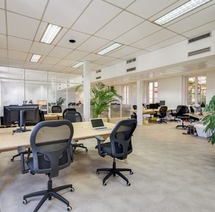 plusieurs bureaux benchs, sièges de bureau et plantes dans un espace ouvert type coworking space