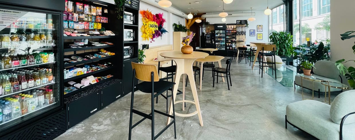 une salle de pause avec table ronde, décoration murales et réfrigérateur