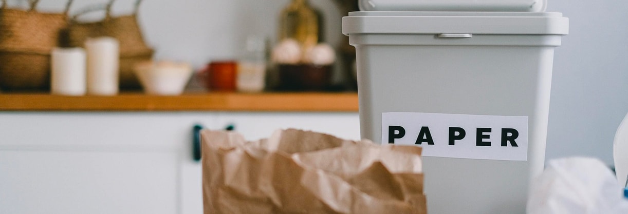 un poubelle grise de recyclage pour le papier avec un plan de travail de cuisine en fond