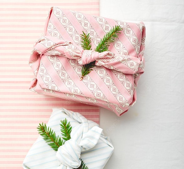 Deux cadeaux roses et blancs emballés avec des tissus type furoshiki