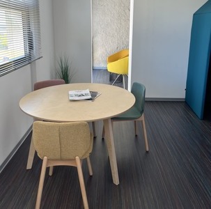 une table ronde avec trois sièges colorés dans un espace détente en entreprise