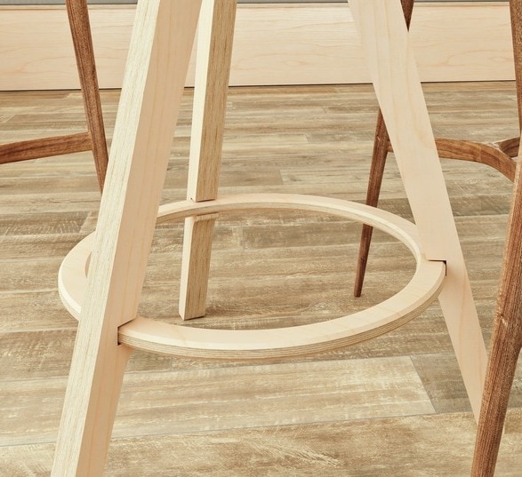3 pieds en bois d'un mange debout avec des pieds de chaises à côté
