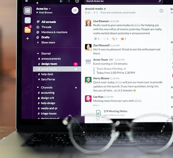 un écran d’ordinateur ouvert sur l’outil numérique slack avec des lunettes posées sur le clavier