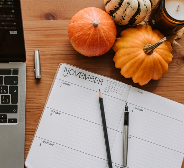 un agenda, des stylos et des légumes d’hiver sur un bureau