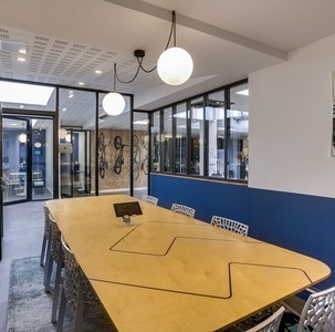 une table de réunion design dans une salle de réunion moderne et ouverte sur un couloir