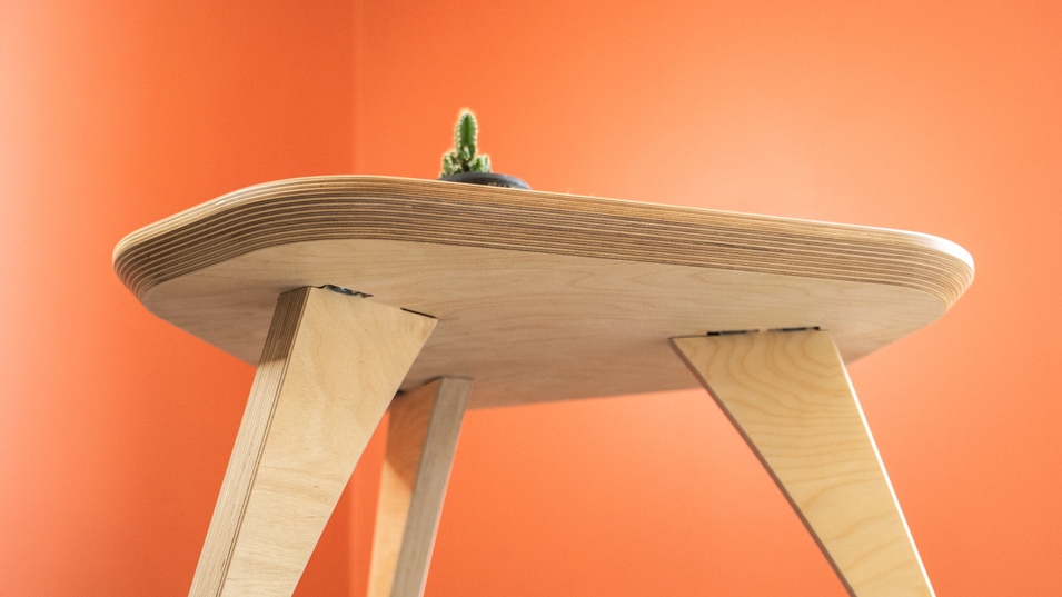 petite table en bois clair dans une pièce aux murs oranges