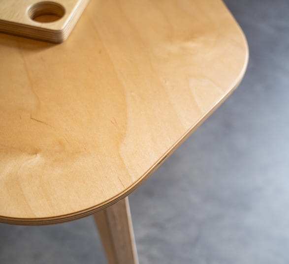 table basse en bois clair posées sur une sol en béton ciré gris foncé