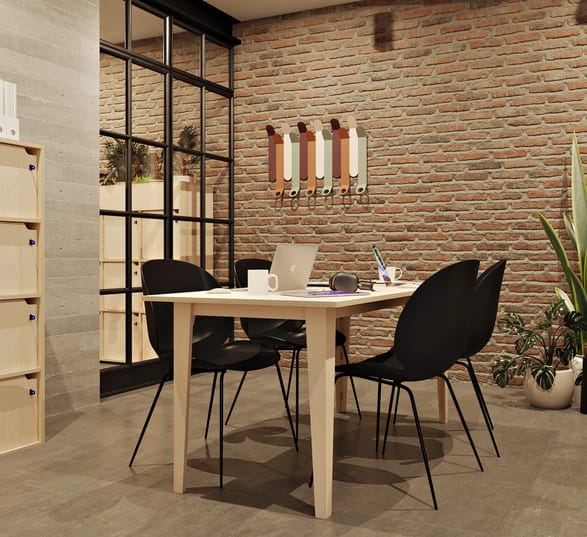 table de réunion rectangulaire en bois clair avec des chaises noires autour dans un bureau décoré dans le style industriel