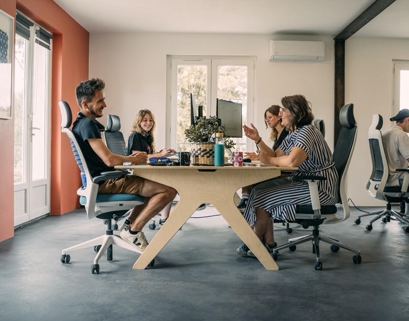 quatre collaborateurs travaillent dans un bureau meublé avec du mobilier de bureau en bois à toulouse