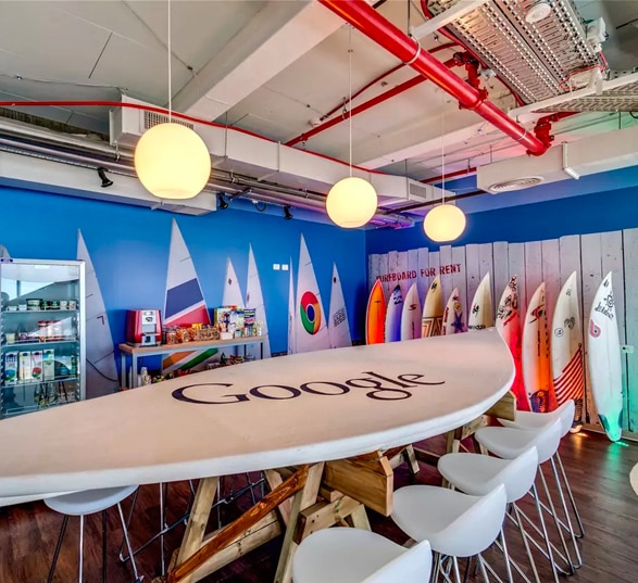 salle de réunion google avec une table de réunion en forme de planche de surf