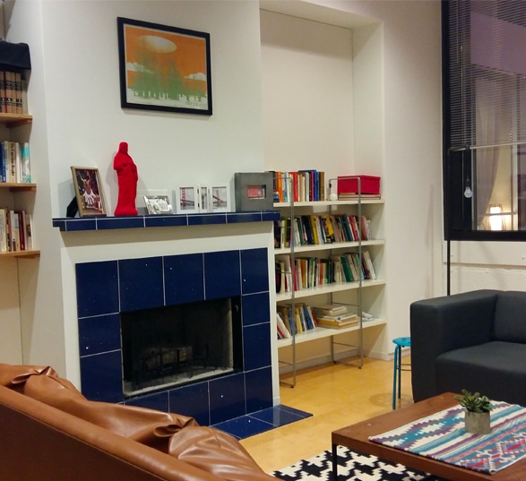 espace salon avec deux canapé, une table basse, une bibliothèque et une cheminée bleu