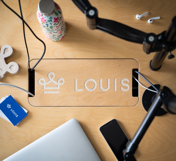 idée d'office branding avec la gravure d'un logo sur un bureau en bois vu du dessus avec des objets déco