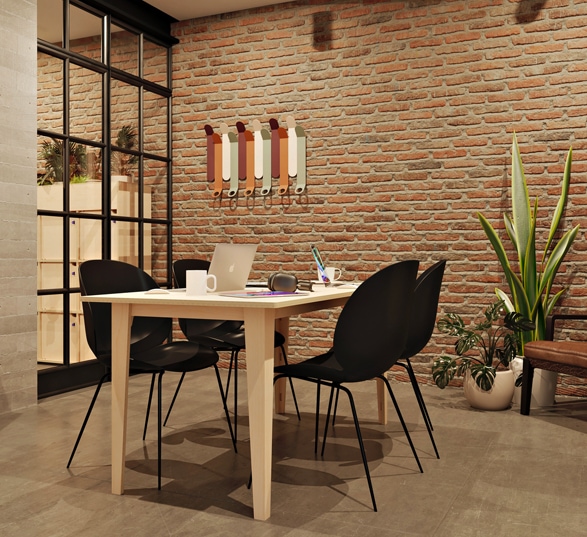 petite table de réunion en bois pour 4 personnes dans une salle avec des murs en briques
