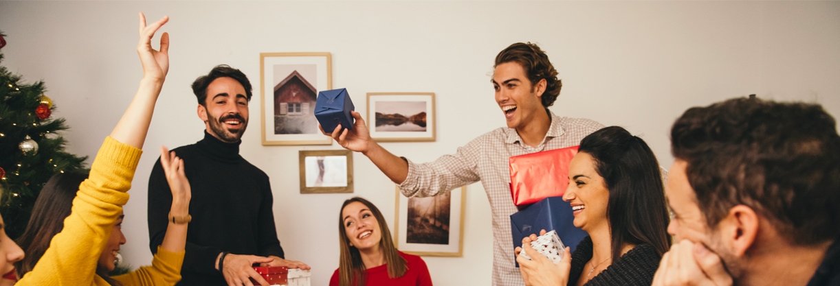 Des collaborateurs fêtent Noël au bureau et s'offrent des cadeaux.