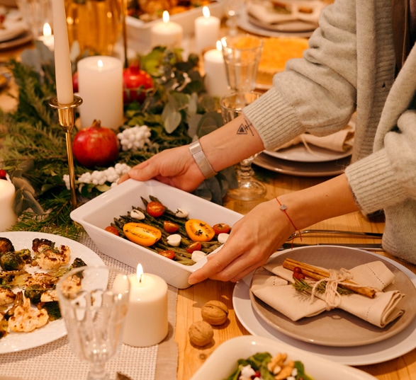 Repas de Noël avec des plats posés sur une table décorée.