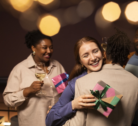 Des personnes s'offrent des cadeaux de Noël et se prennent dans les bras pour se remercier.