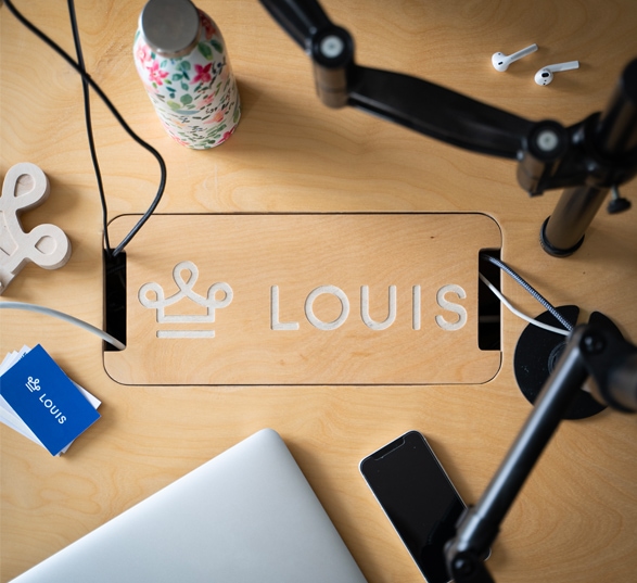 Gravação do logotipo Louis na escotilha de uma mesa de madeira com objetos colocados sobre ela