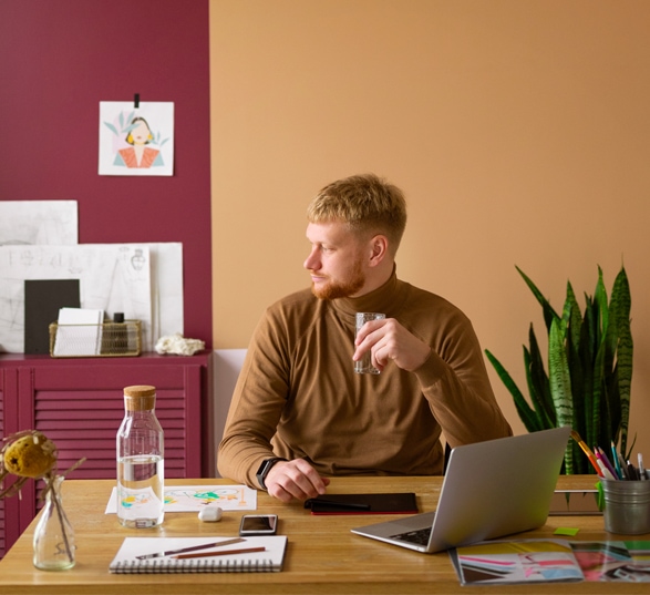 Bureau avec un collaborateur qui travaille et des peinture aux murs couleur terracotta 