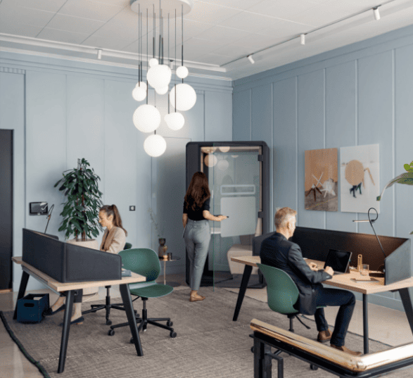 Espace de travail collaboratif avec 2 bureaux individuels, une cabine acoustique et une décoration bleue épurée.