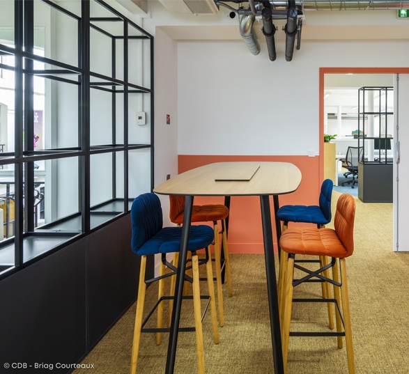 Espace réunion en entreprise avec des murs des couleurs tendances, blanc et orange

